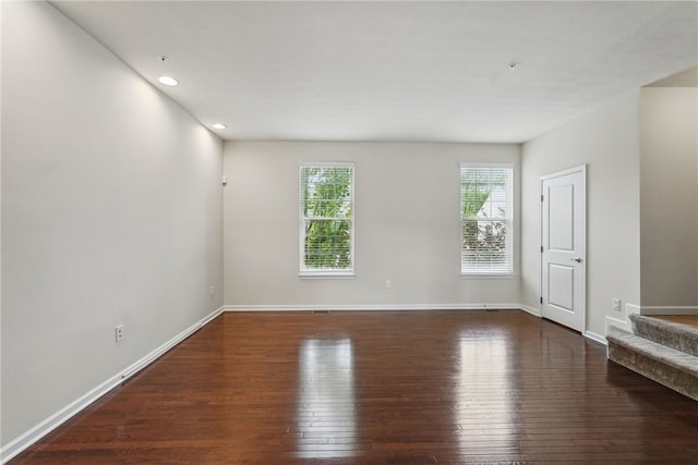 unfurnished living room featuring hardwood / wood-style flooring, stairs, baseboards, and recessed lighting