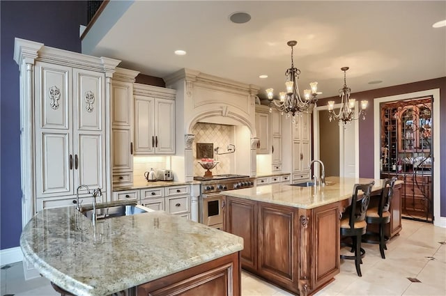 107 Mirage Dr, Cranberry Twp, PA 16066 - kitchen featuring a sink, a large island with sink, high end stainless steel range, a chandelier, and recessed lighting