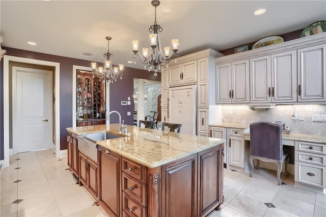 107 Mirage Dr, Cranberry Twp, PA 16066 - kitchen featuring a sink, a chandelier, decorative backsplash, light tile patterned floors, and an island with sink