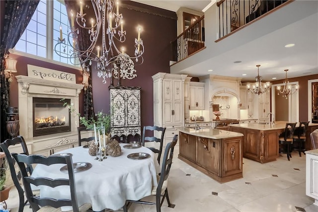 107 Mirage Dr, Cranberry Twp, PA 16066 - dining area with a chandelier, a high ceiling, a glass covered fireplace, and recessed lighting