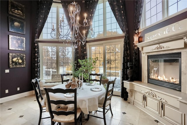 107 Mirage Dr, Cranberry Twp, PA 16066 - dining room with a chandelier, a towering ceiling, light tile patterned floors, baseboards, and a premium fireplace