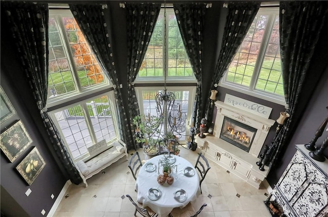 107 Mirage Dr, Cranberry Twp, PA 16066 - living area with a glass covered fireplace, tile patterned flooring, a high ceiling, and baseboards