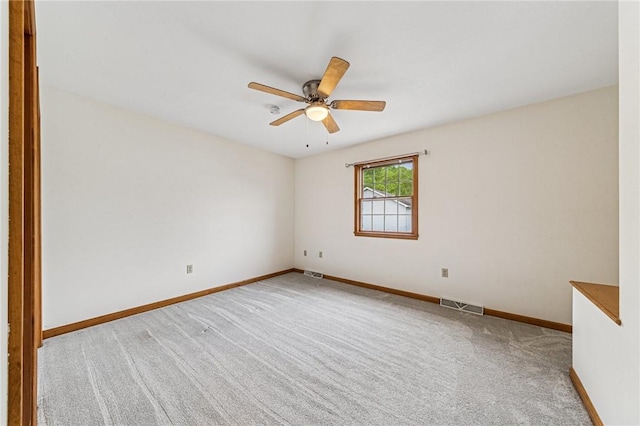 carpeted empty room featuring baseboards and a ceiling fan