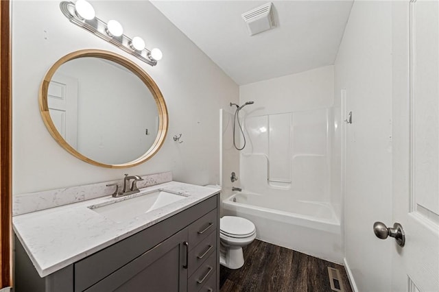 bathroom featuring wood finished floors, toilet, vanity, and shower / bath combination
