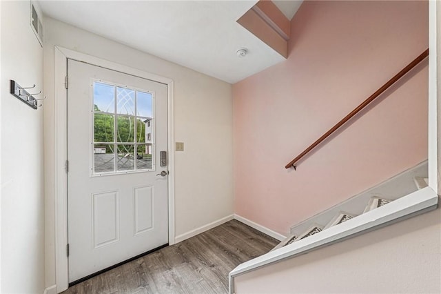 doorway with wood finished floors, baseboards, and stairs