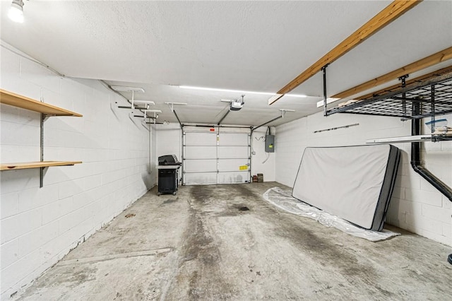 garage featuring a garage door opener, concrete block wall, and electric panel