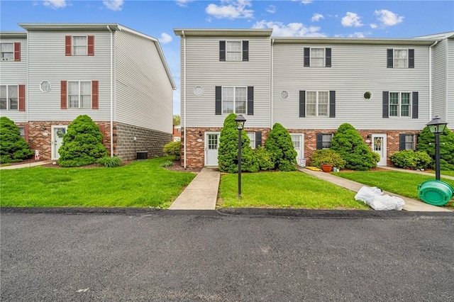 multi unit property featuring brick siding and a front yard