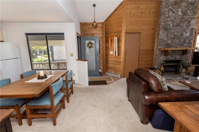 4308 Swiss Mountain Dr, Seven Springs Resort, PA 15622 - living room with a baseboard heating unit, wood walls, light colored carpet, vaulted ceiling, and a stone fireplace