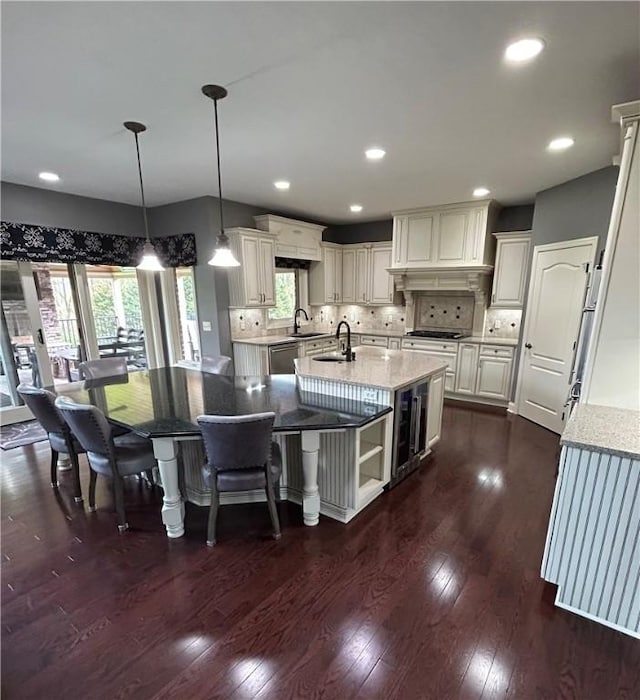kitchen featuring an island with sink, a sink, dark wood-style floors, healthy amount of natural light, and recessed lighting