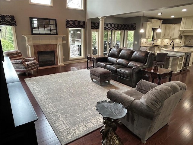 living room with dark wood-type flooring, a fireplace with flush hearth, and recessed lighting
