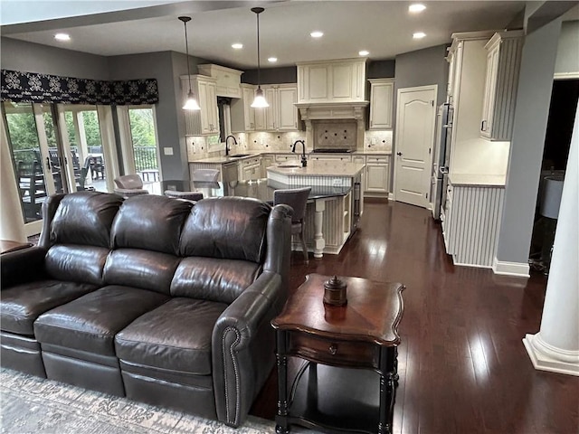 living area with dark wood-style flooring, recessed lighting, and baseboards