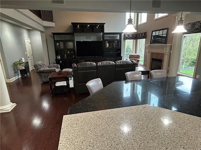 dining area featuring a fireplace, dark wood finished floors, and baseboards