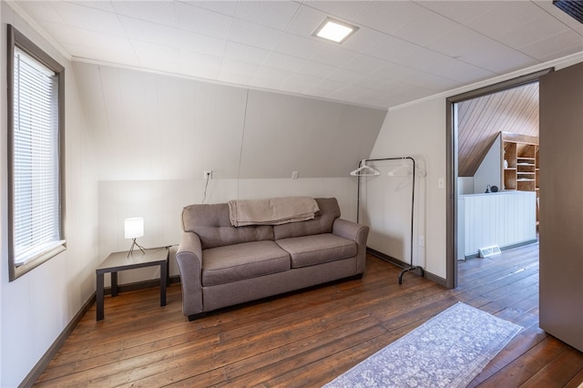 living area with hardwood / wood-style floors, baseboards, healthy amount of natural light, and ornamental molding