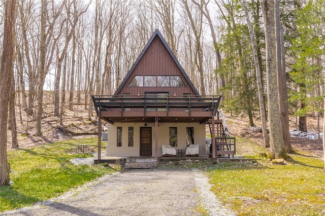 view of front of house with a deck, stairs, and stucco siding