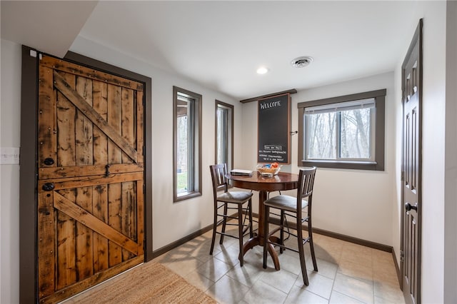 dining room featuring healthy amount of natural light, baseboards, light tile patterned flooring, and recessed lighting