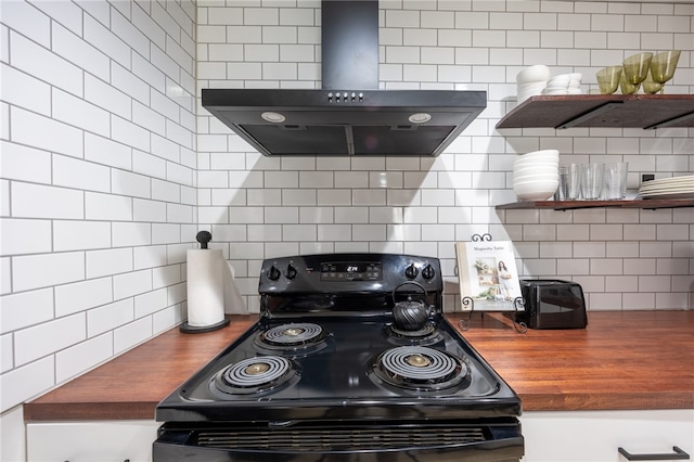 kitchen featuring black range with electric cooktop, wooden counters, wall chimney exhaust hood, and decorative backsplash