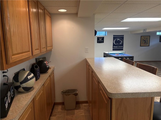 205 S Keel Ridge Rd, Hermitage, PA 16148 - kitchen with a peninsula, brown cabinetry, a paneled ceiling, baseboards, and light countertops