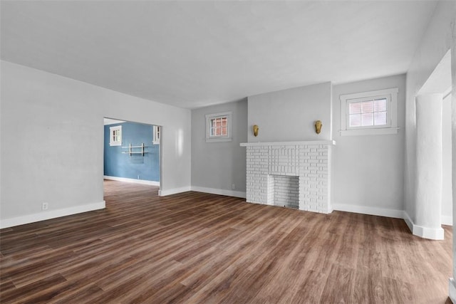 1140 N Negley Ave, Highland Park, PA 15206 - unfurnished living room featuring wood finished floors, a brick fireplace, and baseboards