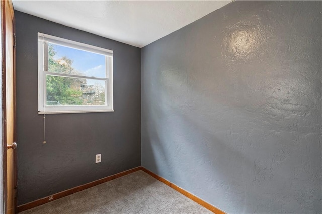 carpeted spare room with baseboards