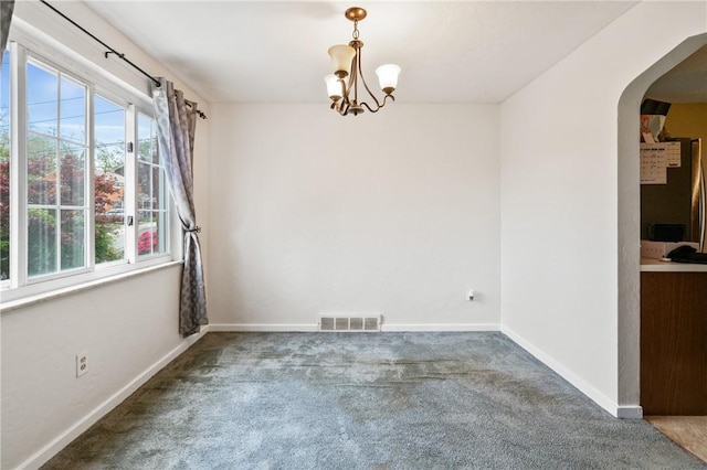 unfurnished dining area featuring arched walkways, carpet, a chandelier, and baseboards
