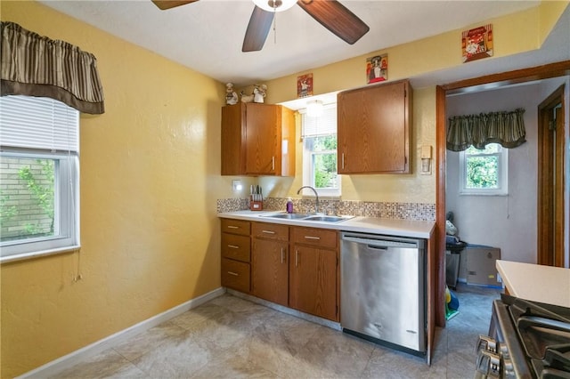 kitchen with appliances with stainless steel finishes, a sink, light countertops, brown cabinetry, and ceiling fan