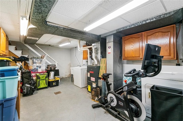finished below grade area featuring a paneled ceiling and washer and dryer