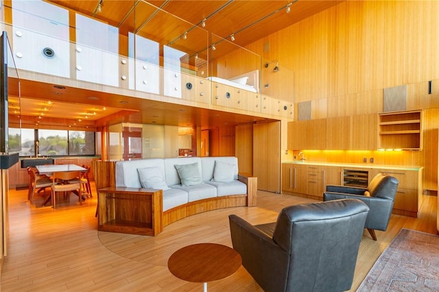 1000 Grandview Ave Unit 1207, Mt Washington, PA 15211 - living room with a towering ceiling, rail lighting, wine cooler, light wood finished floors, and wood walls