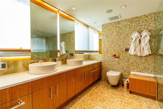 full bath with tile walls, double vanity, toilet, a shower, and tasteful backsplash