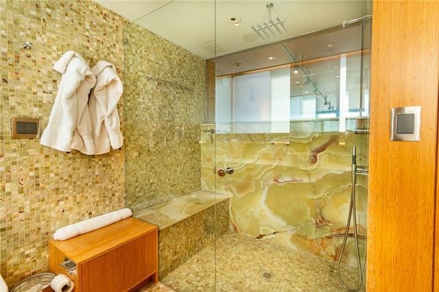 bathroom featuring a shower and tile walls