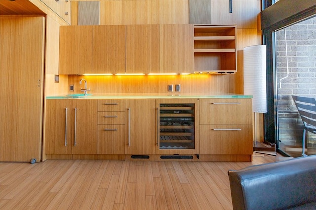 indoor bar with wine cooler and light wood-type flooring