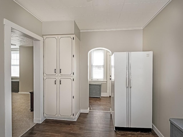hallway with ornamental molding, dark wood-style flooring, baseboards, and arched walkways