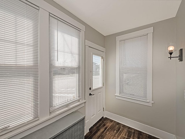 doorway to outside featuring dark wood-type flooring and baseboards