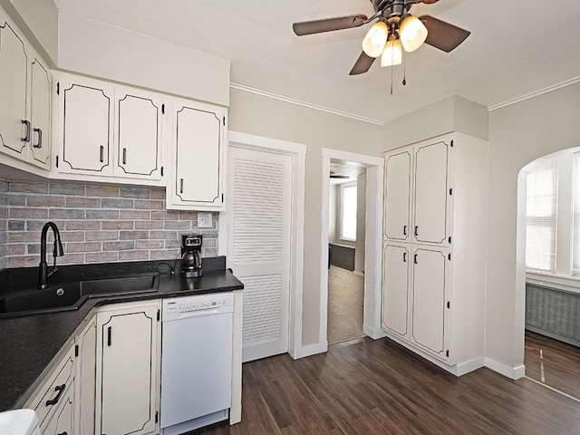 kitchen with dishwasher, a sink, dark countertops, plenty of natural light, and ornamental molding