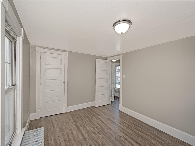 unfurnished bedroom featuring wood finished floors and baseboards