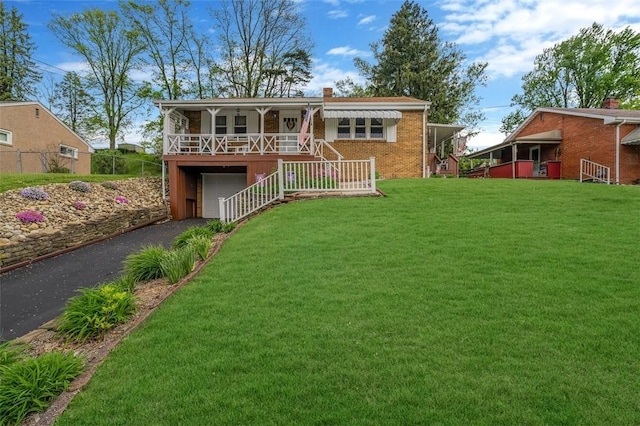 view of front of property featuring a porch, a garage, a front lawn, driveway, and stairway