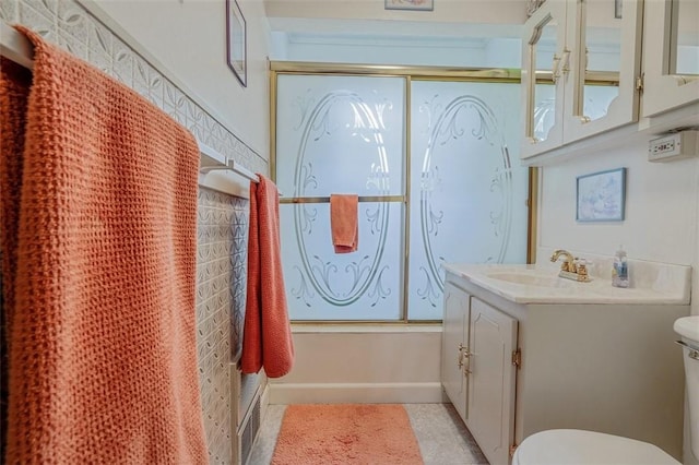 bathroom featuring toilet, vanity, and shower / bath combination with glass door