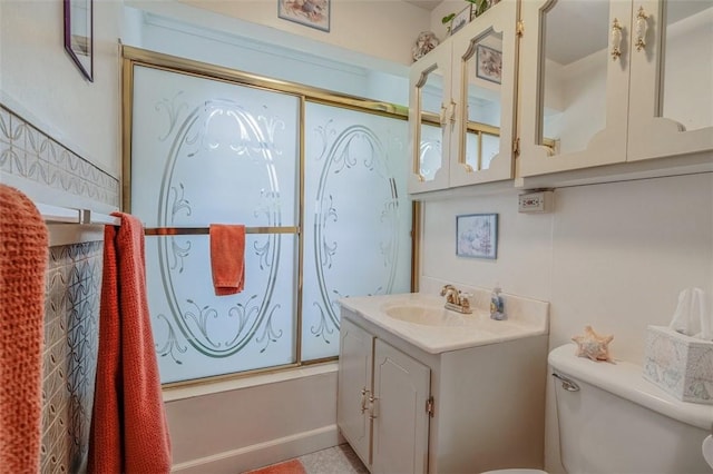bathroom with toilet, vanity, and shower / bath combination with glass door