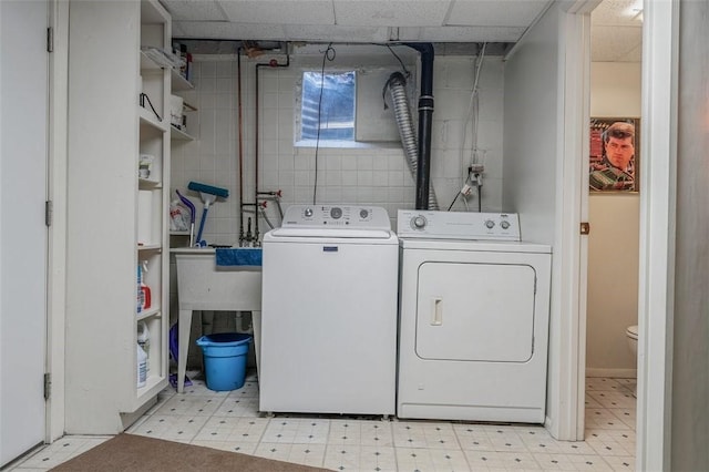 laundry area with washer and clothes dryer and light floors