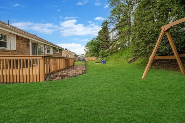 view of green lawn featuring a wooden deck