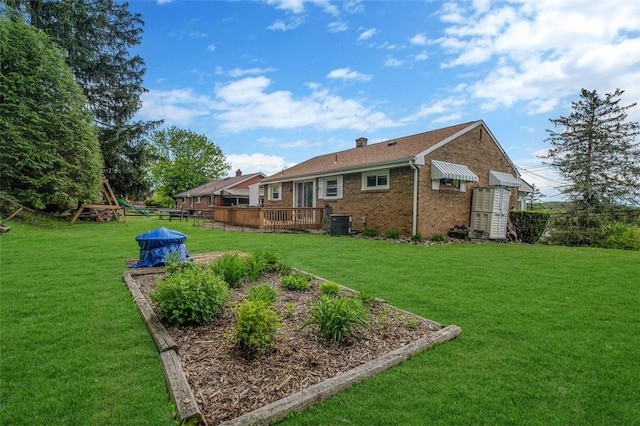 view of grassy yard with a deck and cooling unit