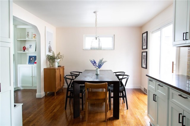 dining room featuring light wood finished floors and baseboards