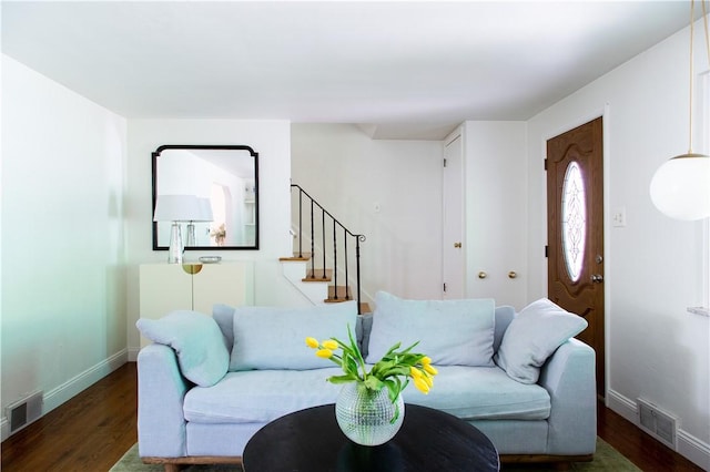 living area with wood finished floors, stairs, and baseboards