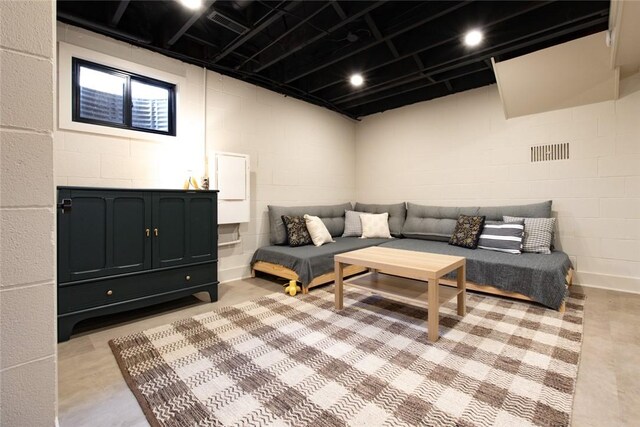 living room with concrete block wall and concrete flooring