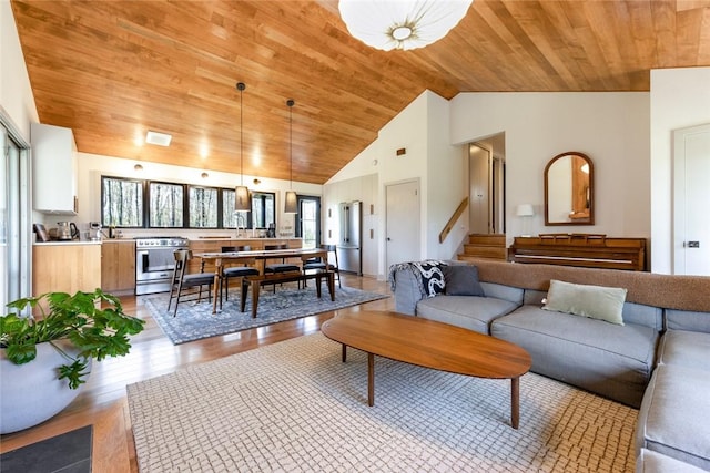 living room with wooden ceiling, light wood finished floors, stairway, and high vaulted ceiling