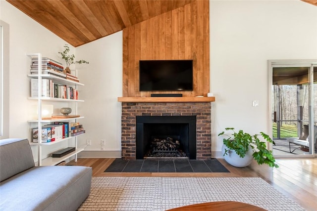 living room with wooden ceiling, wood finished floors, a fireplace, baseboards, and high vaulted ceiling