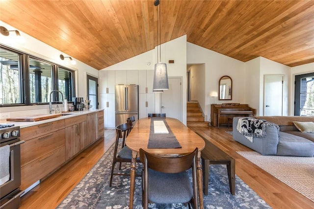 dining space featuring wooden ceiling, vaulted ceiling, and light wood-type flooring