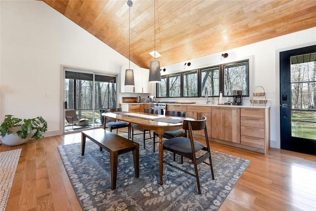dining area with plenty of natural light, wood ceiling, high vaulted ceiling, and light wood-style flooring