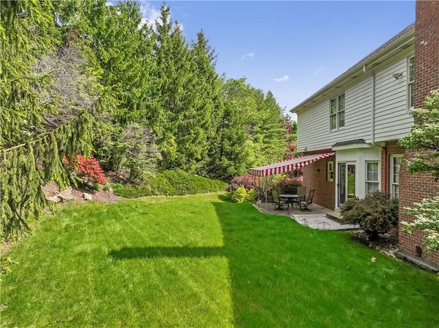 view of green lawn with a patio