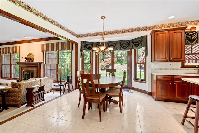 dining space featuring a chandelier, plenty of natural light, light tile patterned flooring, and crown molding