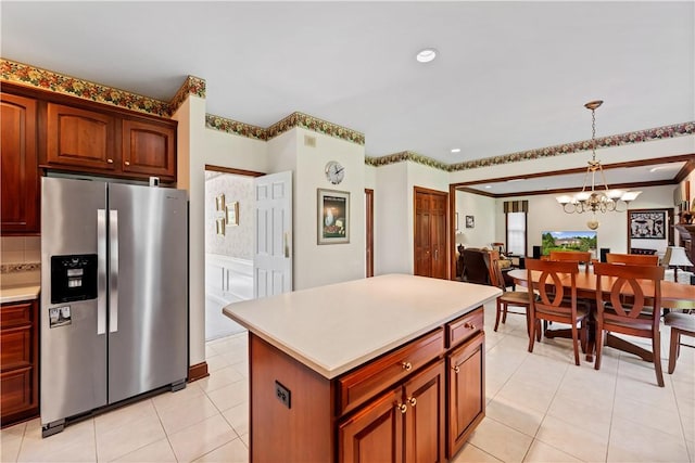 kitchen with stainless steel fridge with ice dispenser, a chandelier, hanging light fixtures, light countertops, and a kitchen island